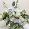 White floral bouquet in a clear glass vase with eucalyptus
