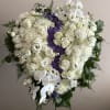 Large white funeral spray with roses and orchids on a stand