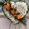 White heart-shaped standing spray of carnations with a diagonal band of orange
