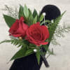 Red rose boutonni&egrave;re with textured greenery and filler.