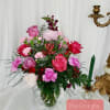 Pink and red mixed flower arrangement in a glass vase