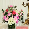 Pink and white floral arrangement in a square glass vase