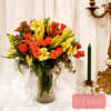 Bouquet of orange roses and yellow lilies in a glass vase