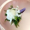 White rose boutonniere with baby's breath and purple wrapped stem
