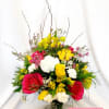 Bright mixed bouquet of pink, yellow, and white flowers in a glass vase