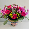 Bright magenta and pink roses mingle with pink-and-white carnations in a cheerful