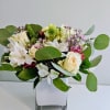 Soft cream roses and white alstroemeria mingle with delicate pink filler blooms