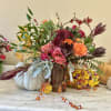 Mixed floral arrangement with pink and orange roses in a wood vase