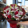 A romantic mix of vibrant roses and elegant pink lilies, accented with