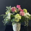 Pink and white floral arrangement in a patterned vase