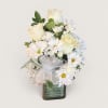 Creamy white roses and delicate white daisies come together in a compact