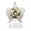 A soft cluster of white roses and lilies framed by feathered angel