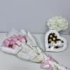 Delicate blush roses beautifully wrapped in elegant white and gold paper, paired