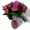 Pink and red mixed bouquet in a glass vase with a ribbon