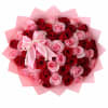 Bouquet of red and pink roses wrapped in pink paper with a pearl bow