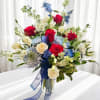 Vivid red roses and creamy white roses mingle with pale blue chrysanthemum-like
