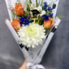 Bright orange roses with a large white chrysanthemum and vivid blue accents