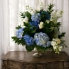 Large clusters of blue and white hydrangeas paired with pure white roses