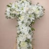 White floral cross arrangement on a wooden easel