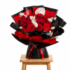 Bouquet of red roses with white flowers wrapped in black and red paper
