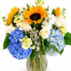 A fresh and vibrant arrangement featuring cheerful sunflowers, elegant white roses, lush