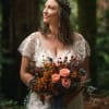 Bride holding a bouquet of peach roses and wildflowers