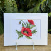 Card with a red poppy cross-stitch design