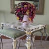 Pink vase with a dense arrangement of dried flowers and berries
