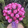 Bouquet of pink roses in a purple vase with a ribbon