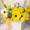 Yellow and white flower arrangement in a white handled box with a yellow ribbon bow.