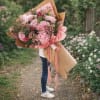 Soft pink hydrangeas take center stage in this lush hand-tied flower arrangement