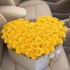 A dense heart-shaped mass of bright yellow roses fills a white presentation