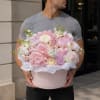 A plush, rounded bouquet of pastel hydrangeas, peonies, ranunculus and garden roses