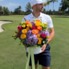 A vivid, joy-filled bouquet in a white round hatbox that reads like