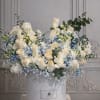 White roses and blue flowers arranged in a round hatbox