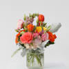 Mixed bouquet of roses and tulips in a textured glass vase