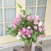 Pink roses and alstroemeria in a decorative vase with ribbon