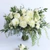 Large white rose and peony bouquet with trailing greenery and a matching white boutonniere.