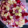 Large bouquet of red, cream, peach, and lavender roses wrapped in pastel paper