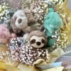 Bouquet of pastel baby’s breath surrounding small plush animals wrapped in yellow paper
