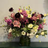 Mixed bouquet of roses and small blooms in a glass vase