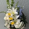 Basket arrangement with white lilies, yellow calla lilies, and blue delphinium