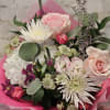 Bouquet of pink and white flowers wrapped in bright pink paper