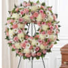 Soft pink roses and pale cream chrysanthemums form a gentle halo in
