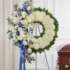 A circular wreath of pure white chrysanthemums edged with deep green foliage