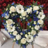 Heart-shaped floral wreath with white roses, daisies, and blue flowers