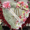Heart-shaped floral wreath on an easel with pink and white flowers and a ribbon