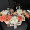 Peach roses and white dahlias in a gift basket with a ribbon