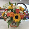 Mixed bouquet with sunflowers, roses, and carnations in a decorative pot