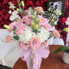 Pink and white bouquet in a clear vase with a birthday topper